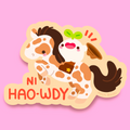 A cute die-cut sticker featuring a cute cartoon horse with brown spots and a rider holding a brown hat, with the text 'NI HAO-WDY' in red-orange lettering, shown on a solid pink background.